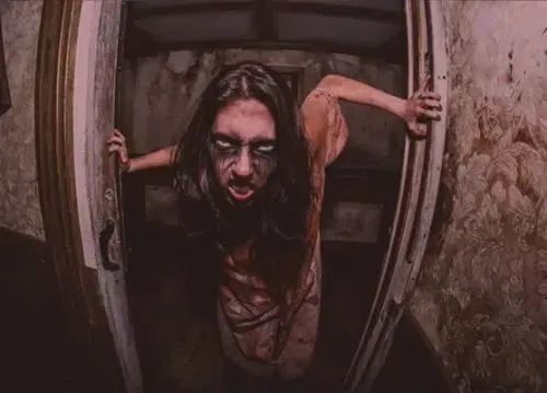Zomebie woman stumbling toward the camera at The Haunted Hotel Mission Valley